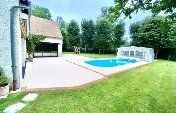Application d'une moquette de pierres sur une terrasse et autour d'une piscine