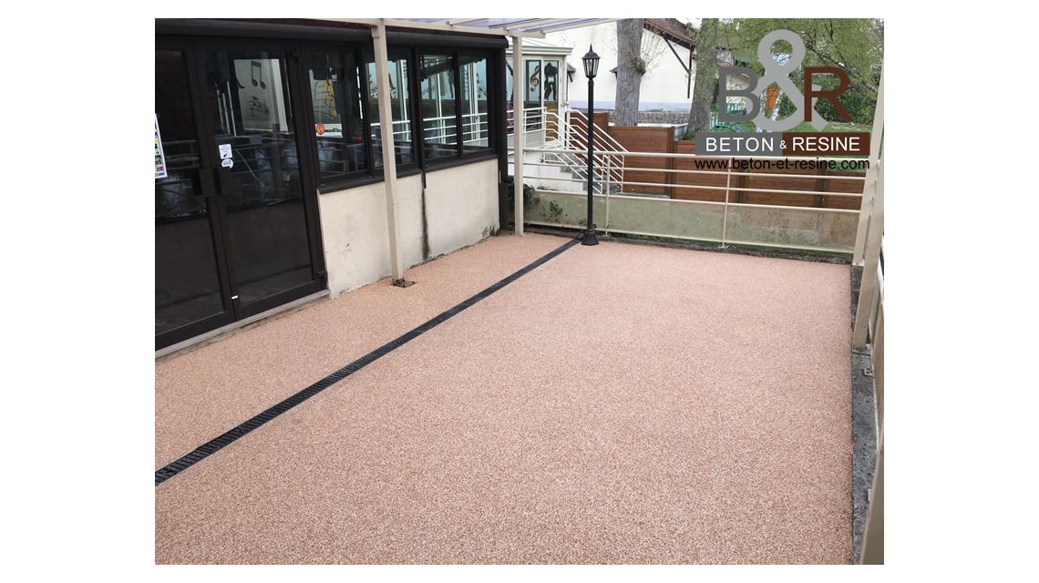 Chantier de tapis de marbre pour un restaurant dans l'Essonne (91) L'ancienne terrasse en bois a été déposée. Nous avons ensuite préparé minutieusement le support et traité les fissures. Nous avons appliqué un tapis de marbre (granulat de marbre mélangé avec un liant résine : breccia pernice).  